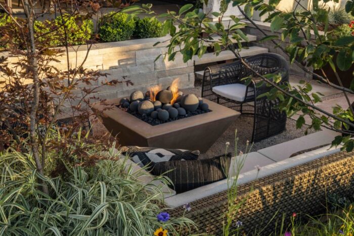 A backyard with a fire pit and plants designed for feng shui.