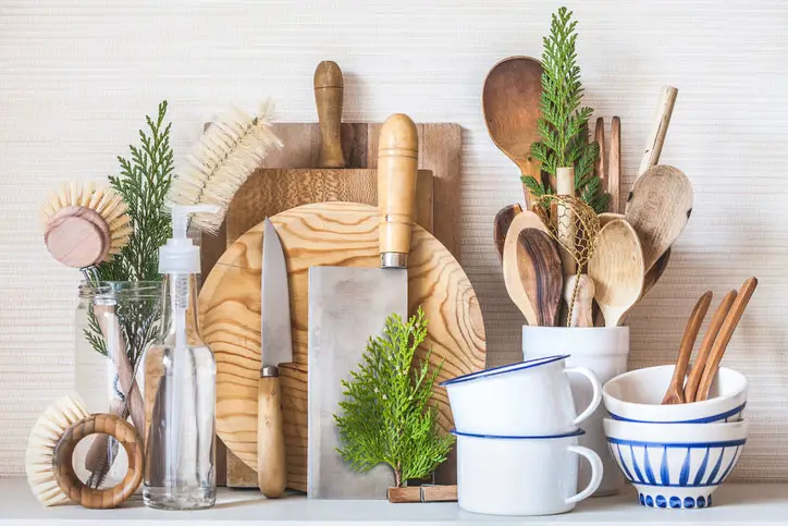 Wooden kitchen utensils and pots on a shelf.