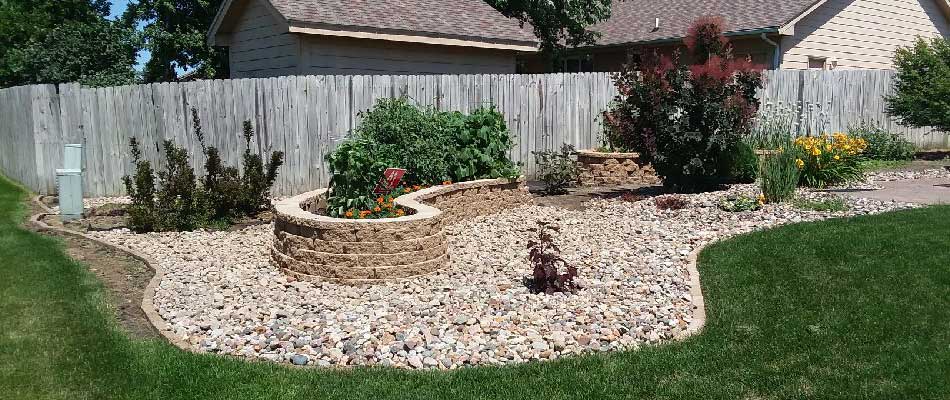 A landscaping project featuring a backyard with a rock garden and a fence.