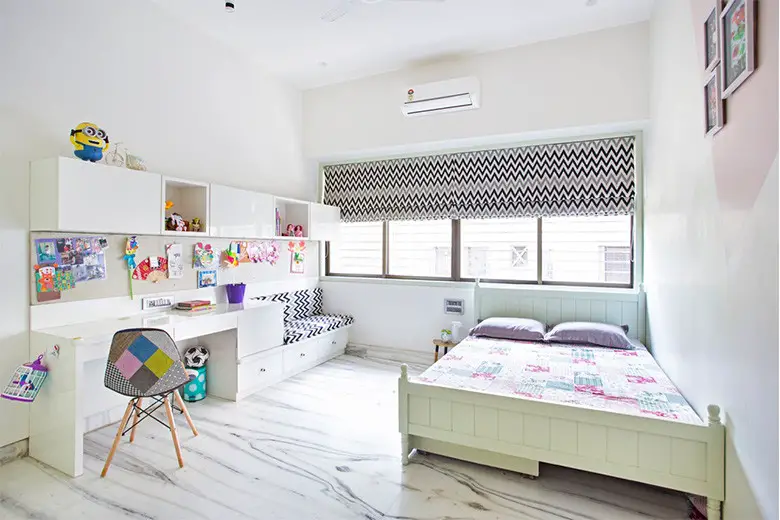 A child's bedroom with a desk and a bed.