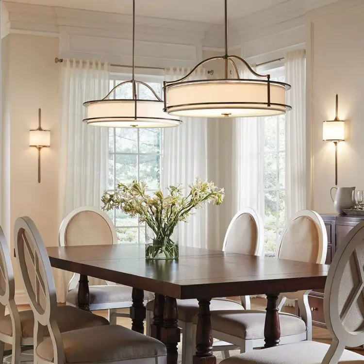 A dining room with a white table and chairs.