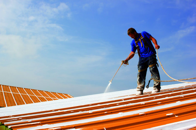 A man re-coating a roof.
