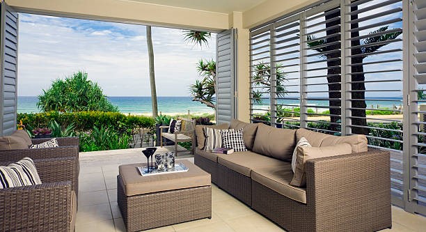 A waterfront condominium with wicker furniture and a view of the ocean.