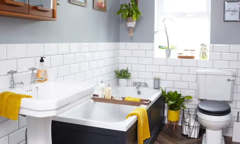 A white bathroom with yellow towels and a toilet.