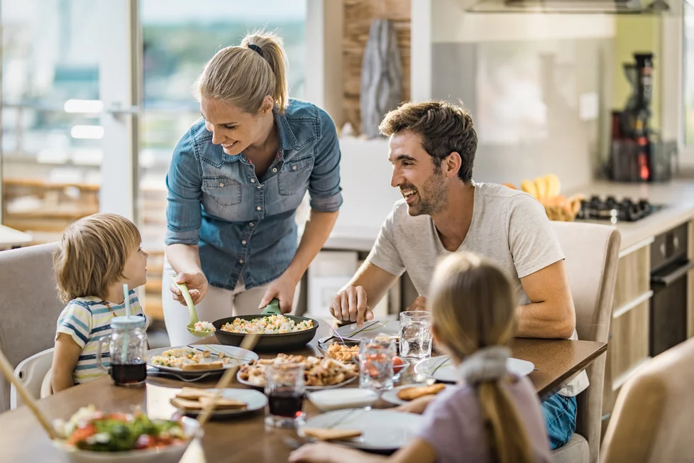 A family eats dinner together in a kitchen.