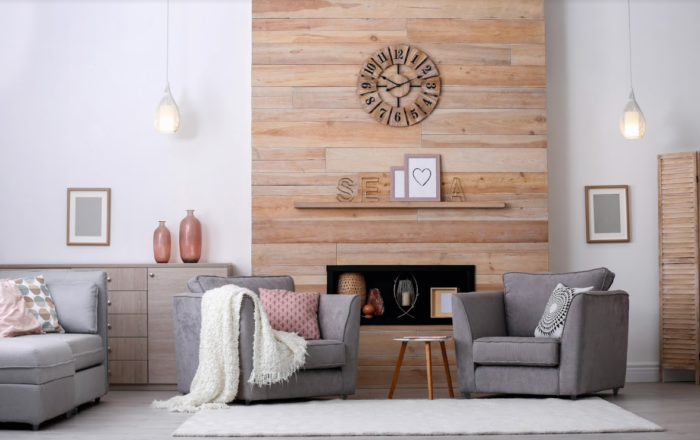 A living room with grey furniture and decorative wall panels.