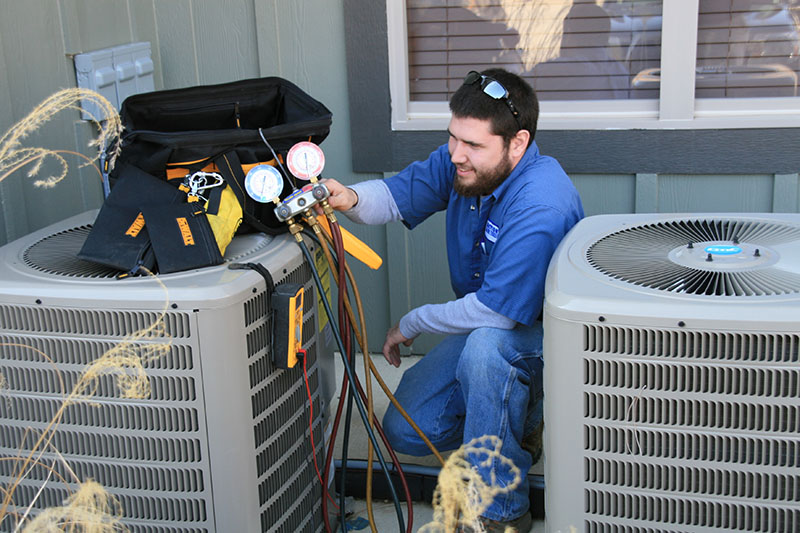 An HVAC technician servicing an air conditioning unit.