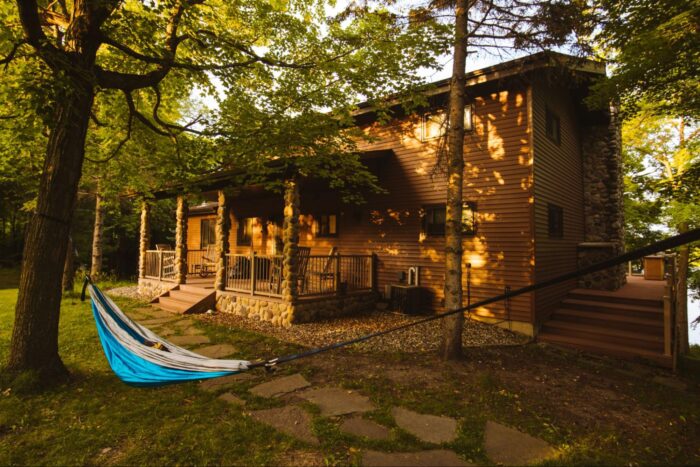 A vacation home with a blue hammock hanging in front.
