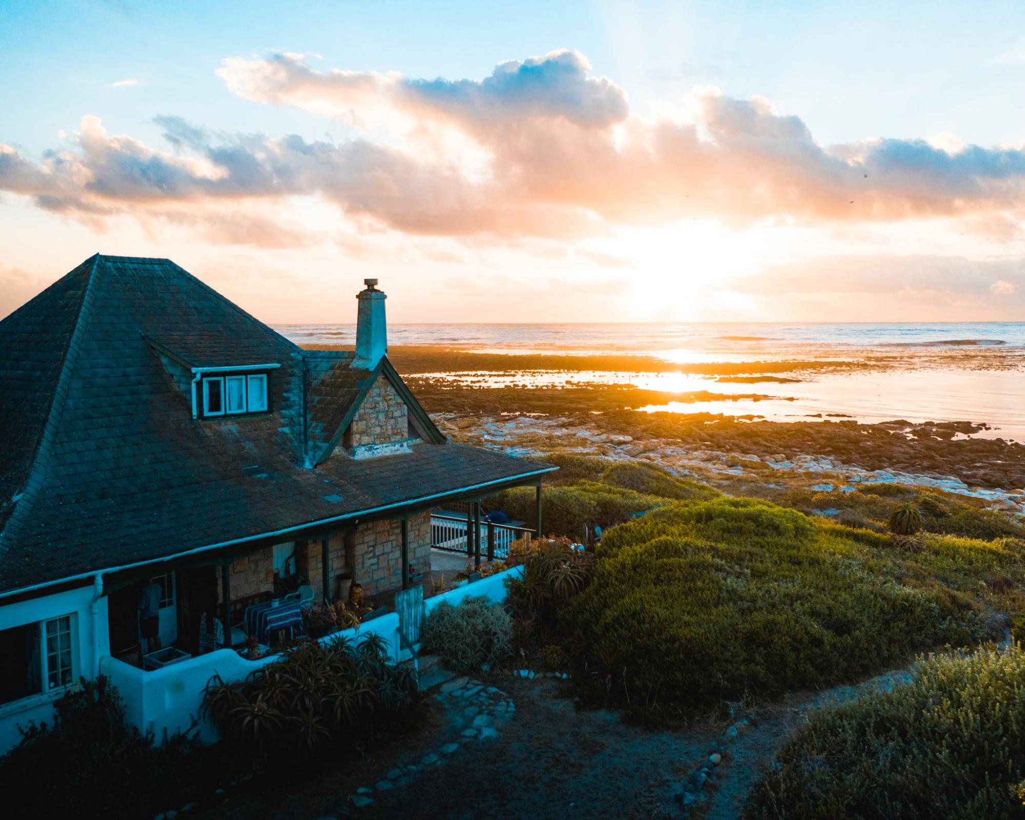 An aerial view of a vacation home on the beach at sunset.
