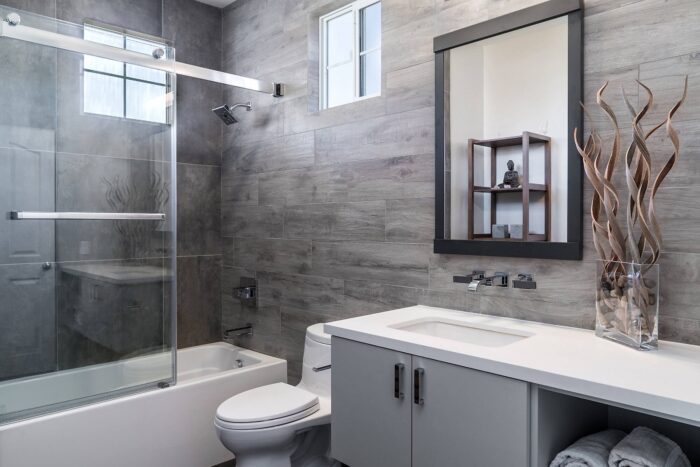 A modern bathroom featuring a glass shower and toilet, ideal for bathroom remodeling.