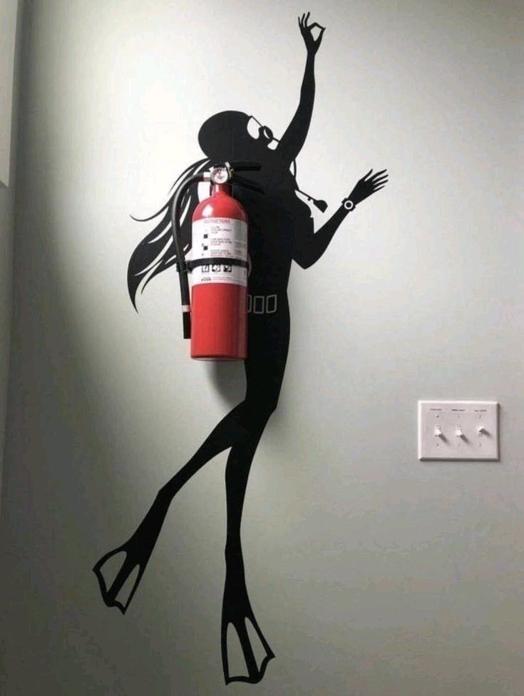 A wall decal creatively blends a scuba diver silhouette with a fire extinguisher, merging art and essential survival equipment.