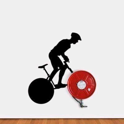 A silhouette of a cyclist riding a bike on a wall, blending art and survival with fire extinguishers.