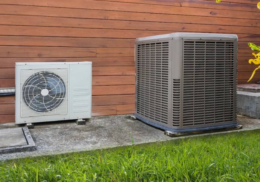 Two heat pumps in front of a house.