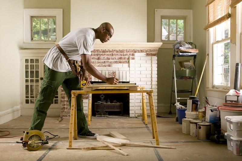A man renovating a table at home.