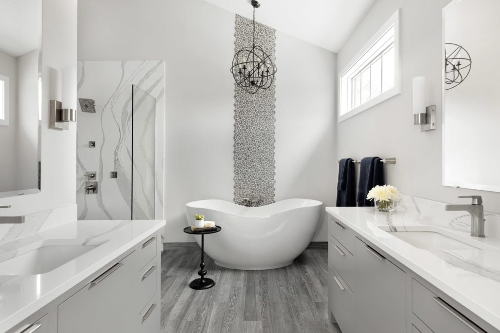 A white and gray bathroom with a tub designed for contemporary living.