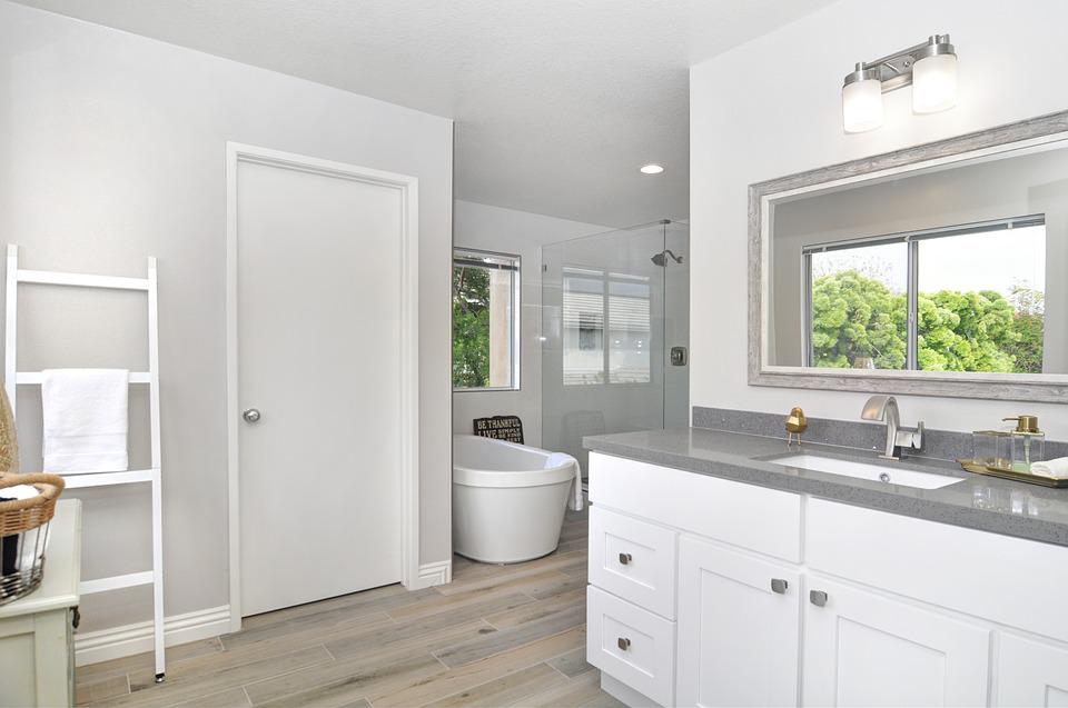 A bathroom with white cabinets and wood floors featuring valuable upgrades.