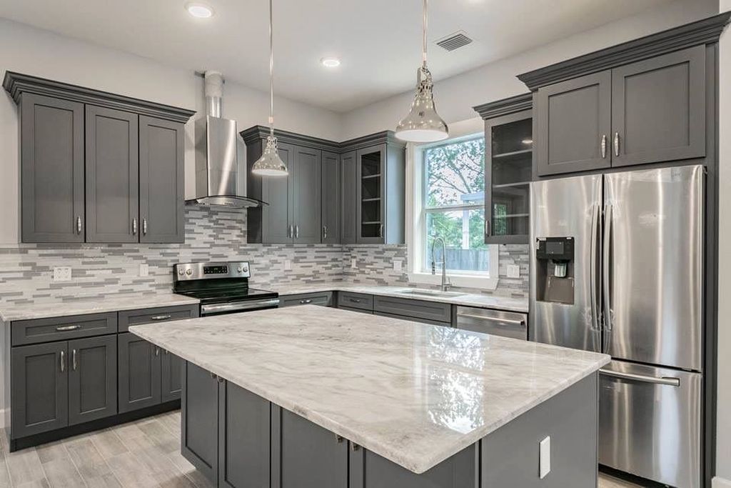 A kitchen with marble countertops and stainless steel appliances.