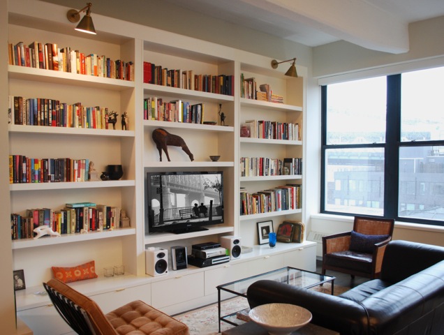 A timeless living room with bookshelves and a tv.