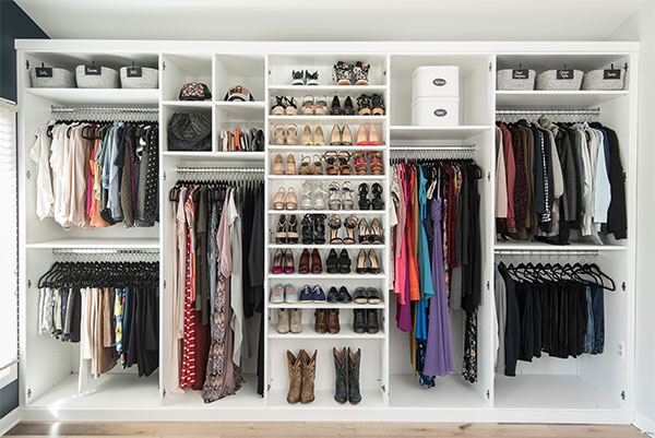 A closet with a lot of clothes and shoes, in need of organizing.