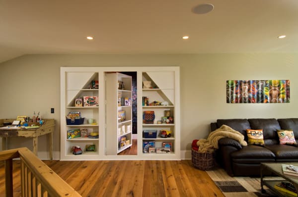 A living room with bookshelves, a couch, and a secret door.