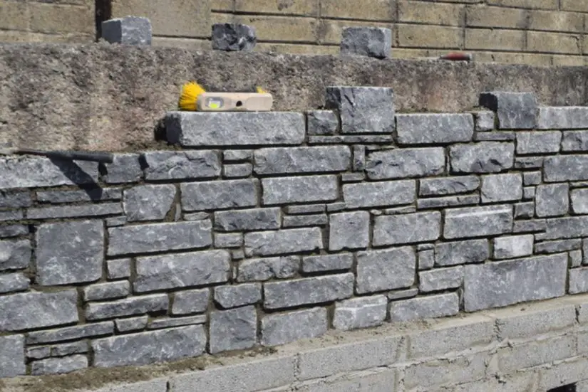 A stone wall is being built in front of a building.