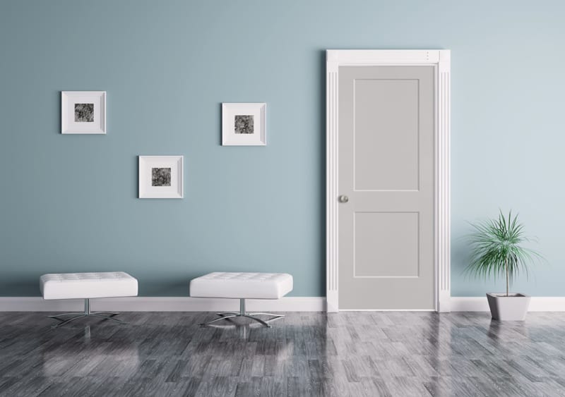 An interior white door in a room with blue walls.