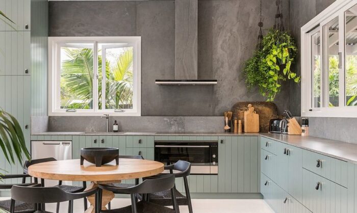 A kitchen with a table and chairs and green walls showcasing design styles.
