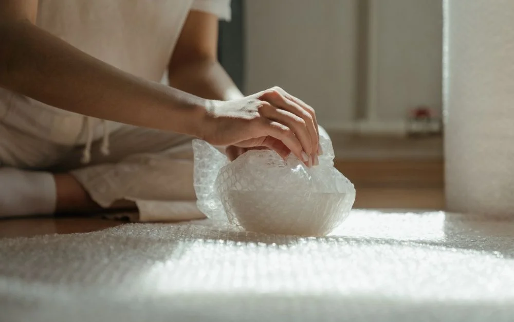A woman is using bubble wrap.
