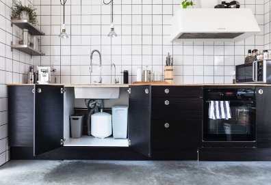 A black and white kitchen with a water purification sink and dishwasher.