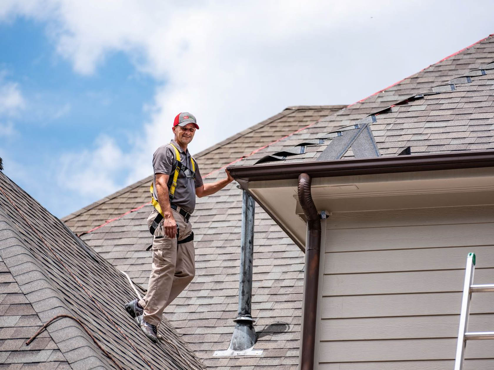 A roofing contractor standing on a roof.