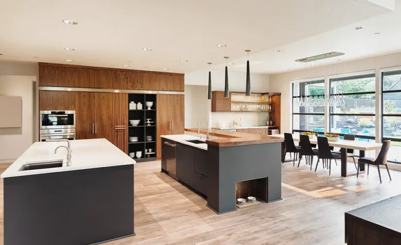 A modern kitchen with wooden cabinets and a dining table.