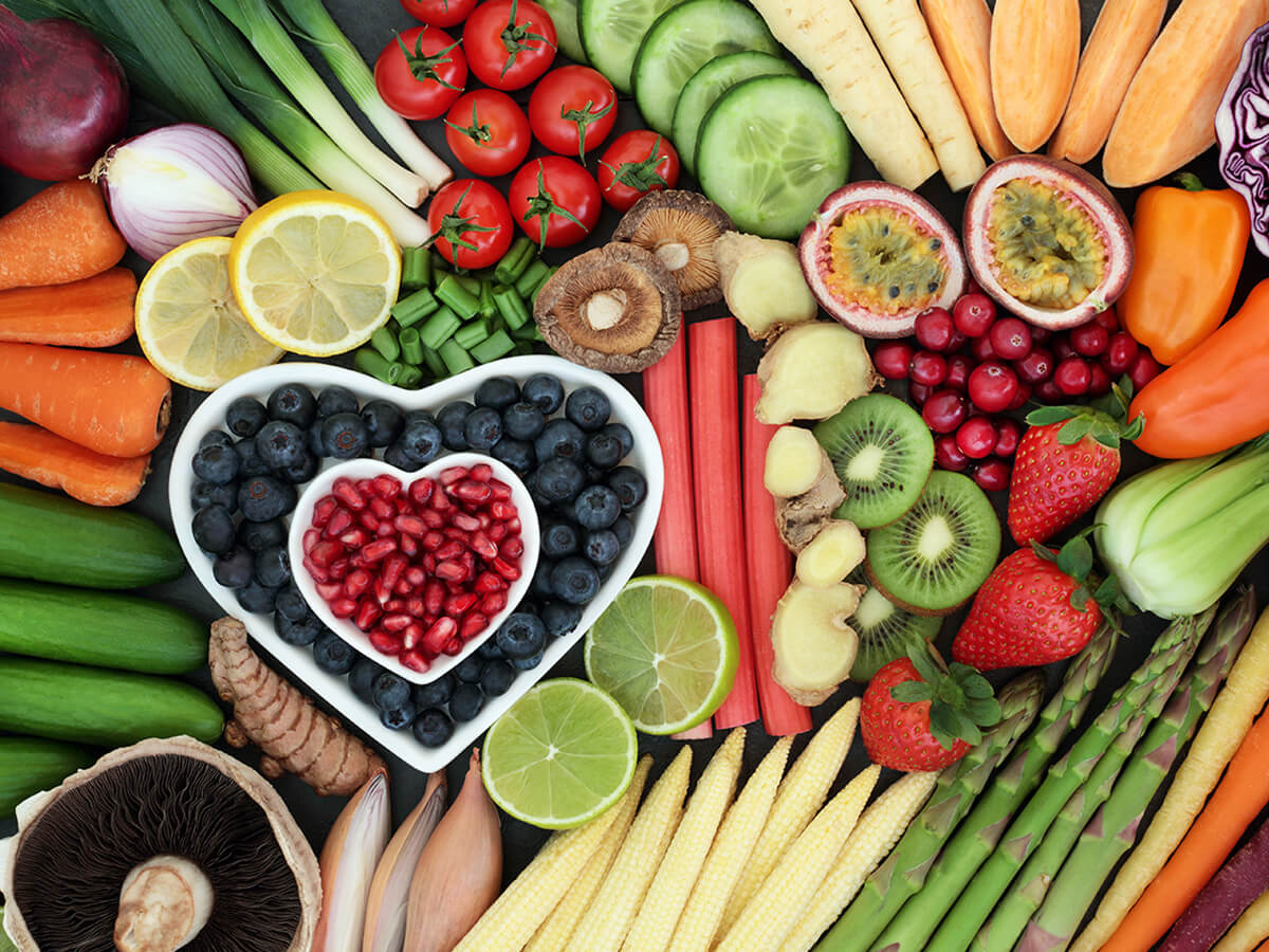 A heart shaped arrangement of plant-based fruits and vegetables.