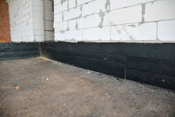 A black concrete wall is being built in front of a building.