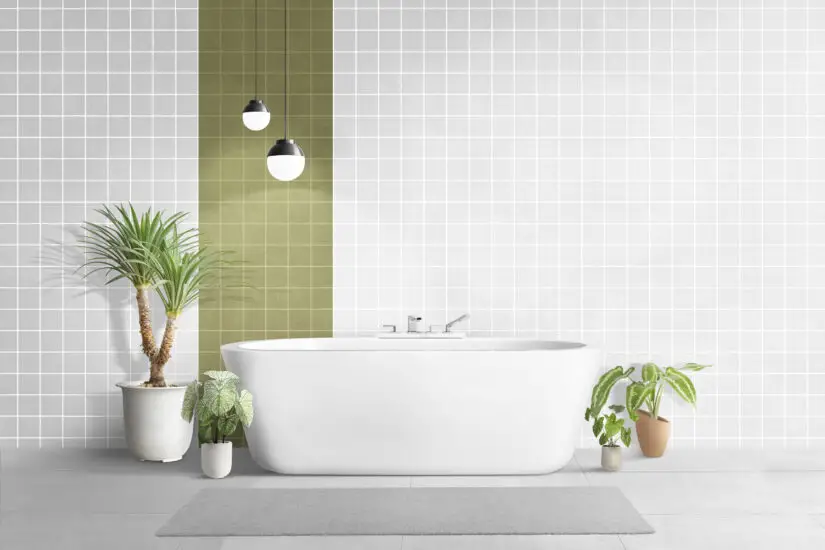 A white and green bathroom with plants and a bathtub.