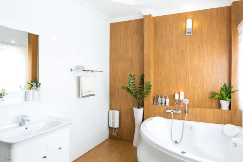 A bathroom with white walls and wooden floors.
