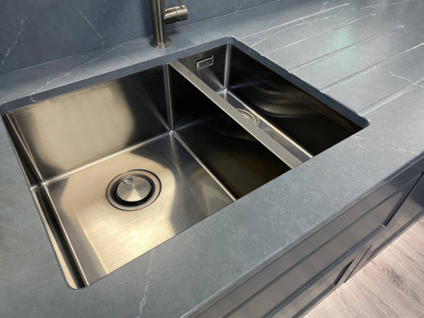 A stainless steel kitchen sink in a contemporary kitchen.