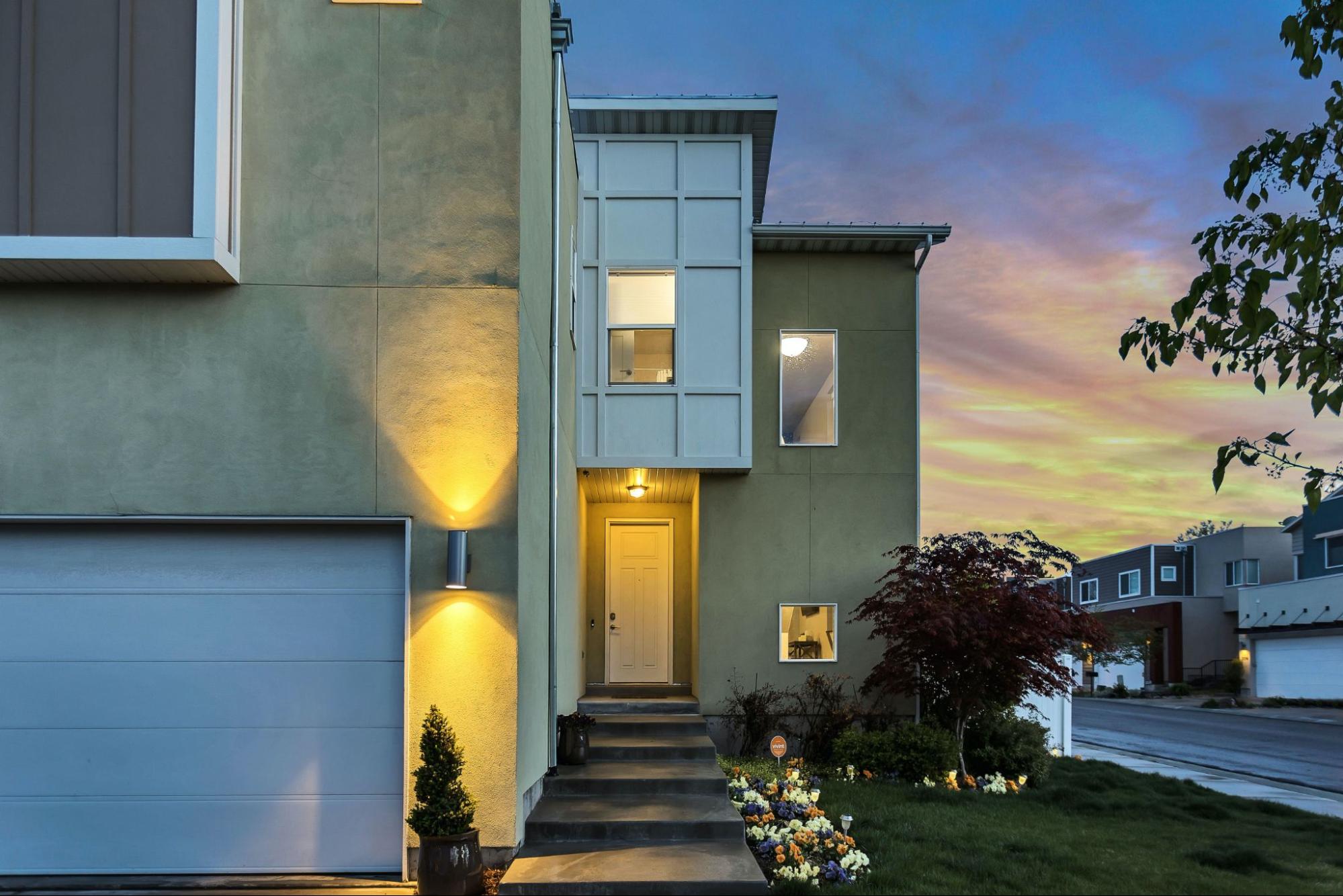 The exterior of a modern home with the best outdoor lighting at dusk.