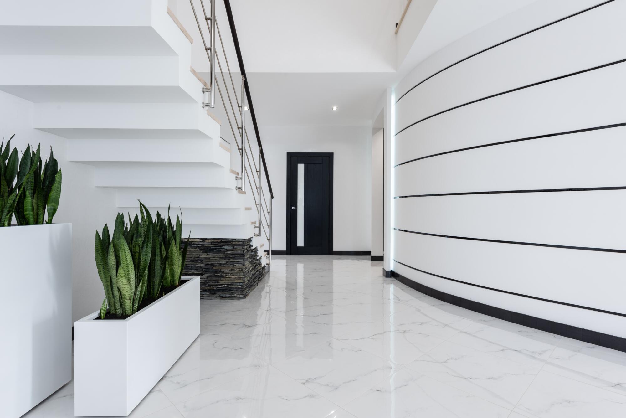 A white hallway with wood effect porcelain tiles.