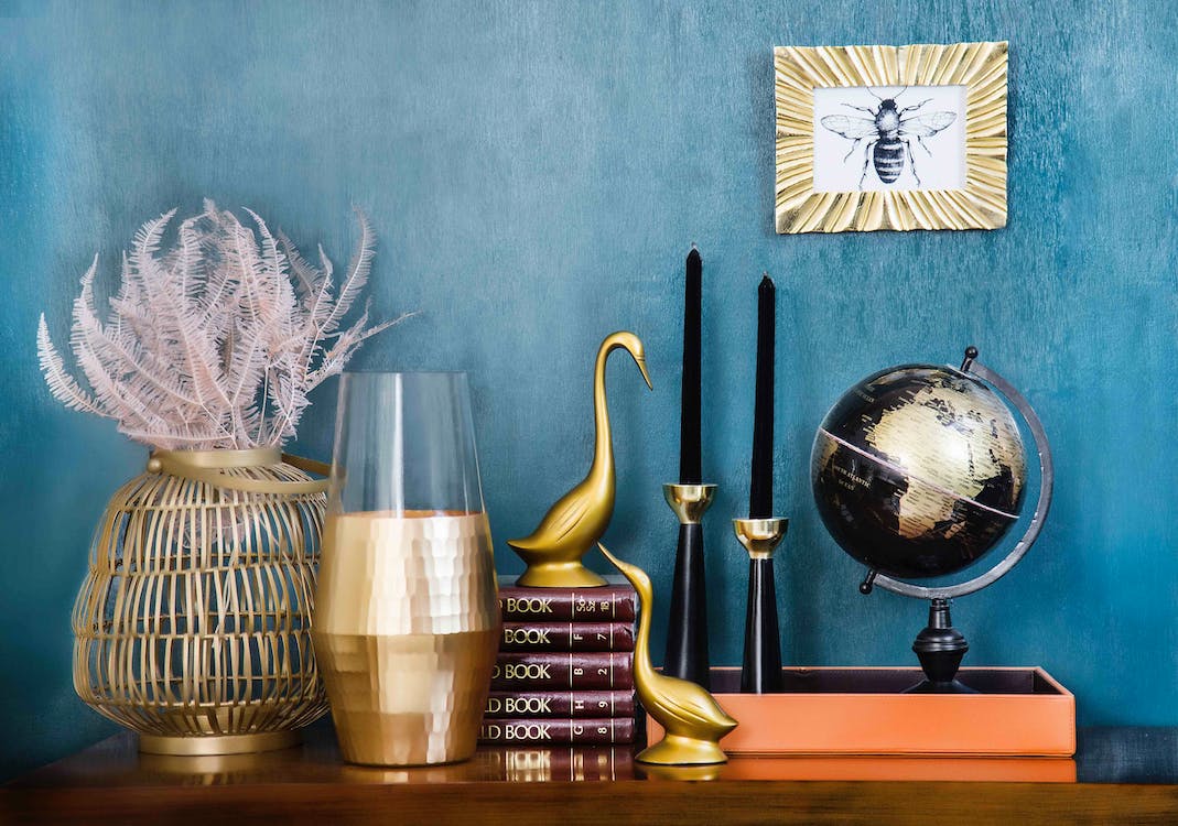 A home decor blog on Instagram featuring a blue wall adorned with vases, books, and a globe.