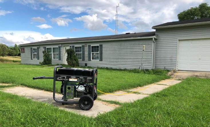 A portable generator positioned in front of a house for optimal placement.