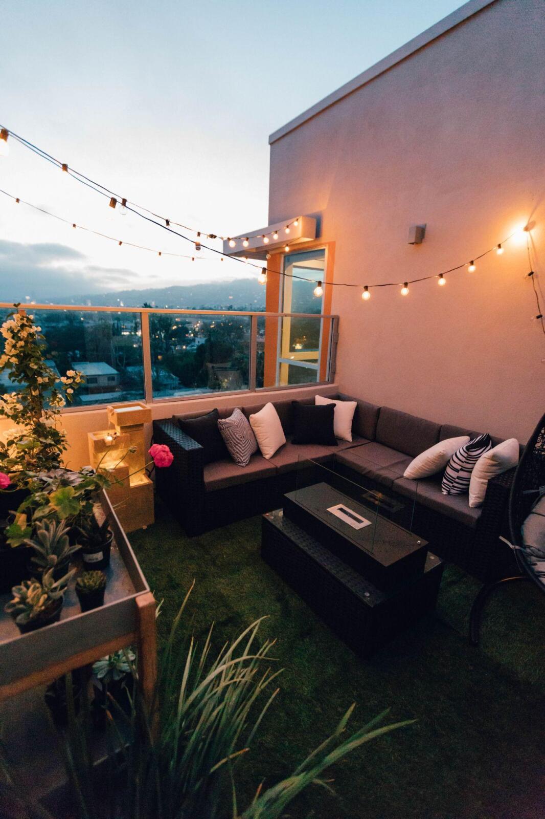 A rooftop patio with cozy string lights, providing the best outdoor lighting.