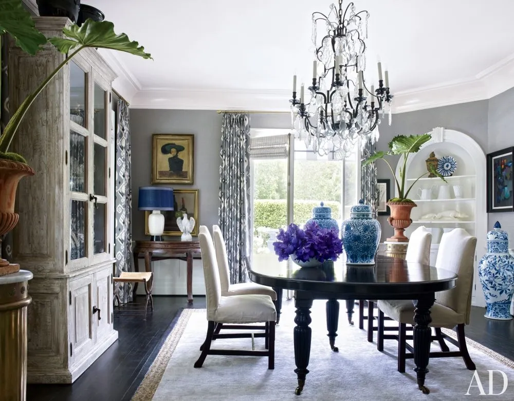 A formal dining room with a chandelier and blue vases.