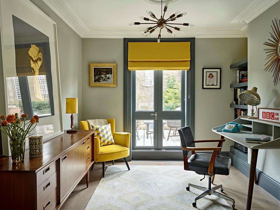 A vibrant home office with yellow accents and a stylish chair.