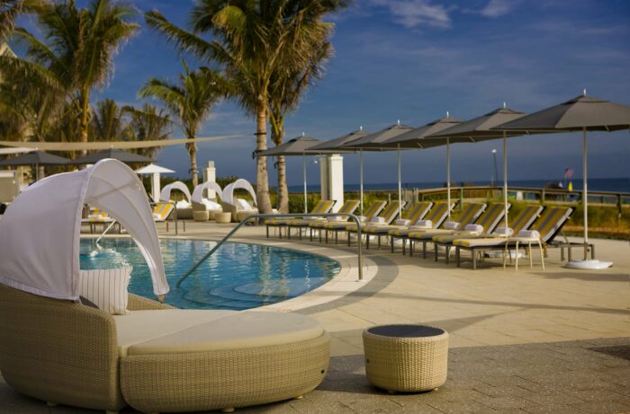A pool with lounge chairs and umbrellas in Florida.