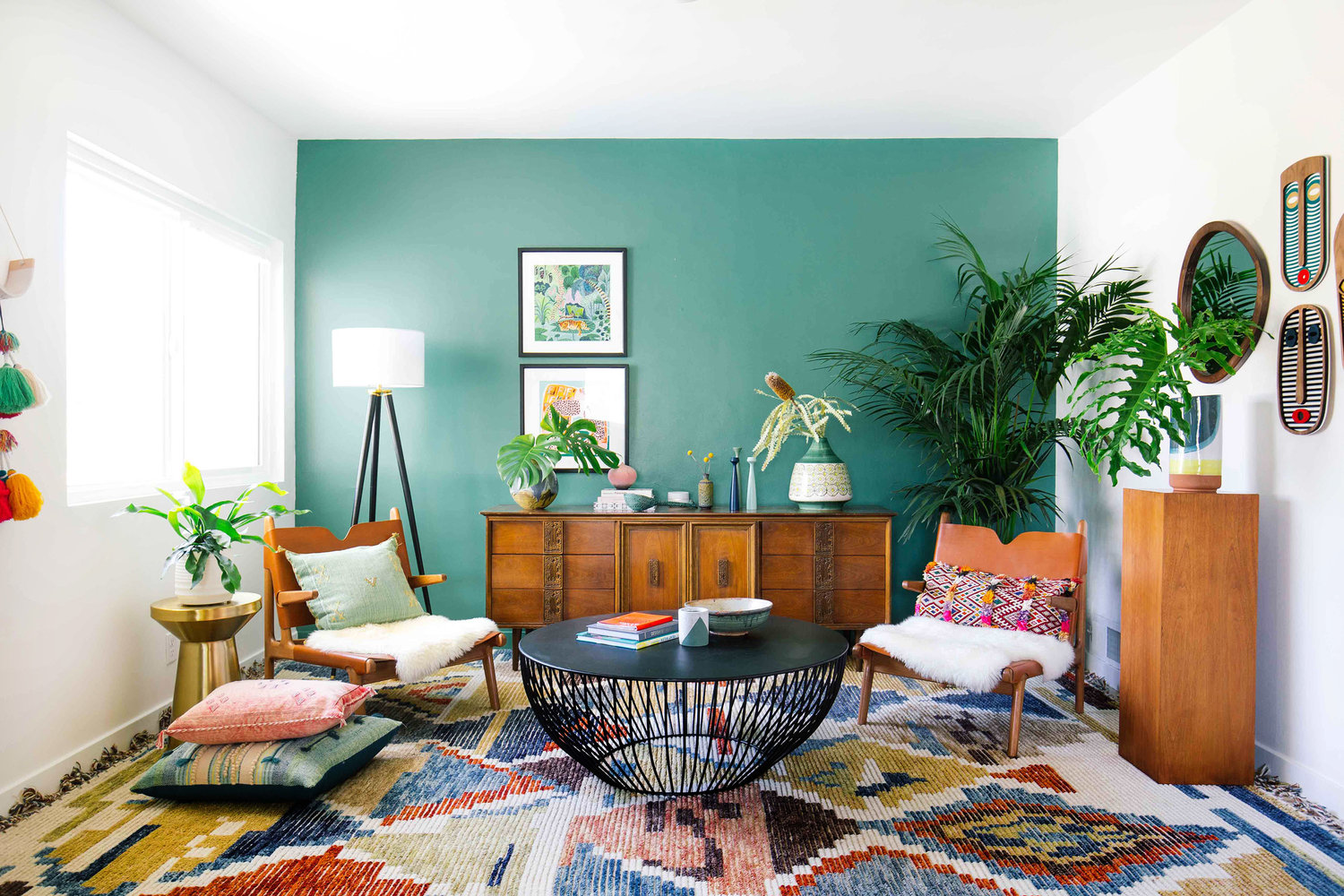 Living room with green walls and a colorful rug designed for a vibrant ambiance.