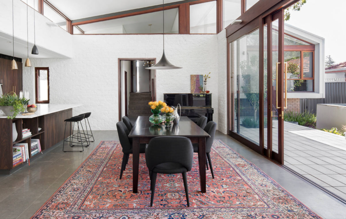 A formal dining room with a rug.