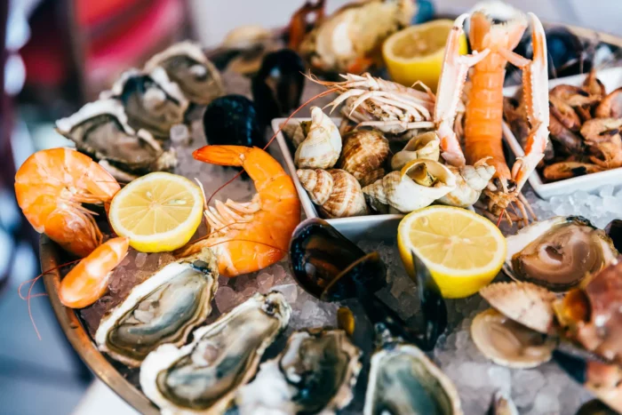 A tray of Florida seafood on a table with lemon wedges.