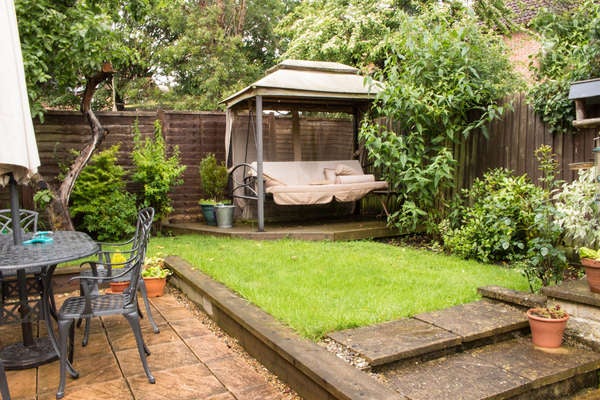 A upgraded backyard featuring furniture and a gazebo.