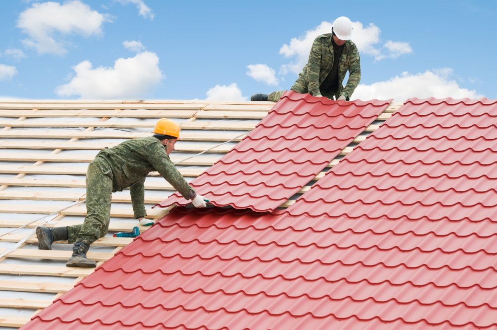 Two men working on a commercial roof installation.