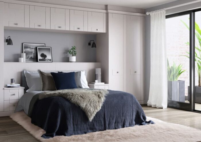 A bedroom with a fitted wardrobe around the bed.